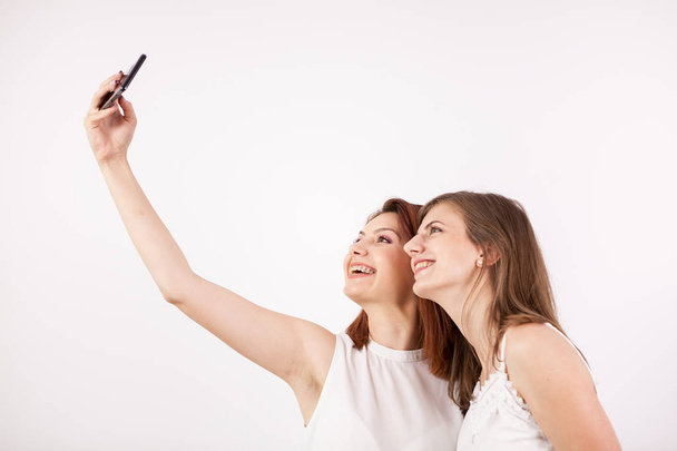Nahaufnahme Porträt von zwei schönen jungen Frauen, die ein Selfie machen - Foto, Bild