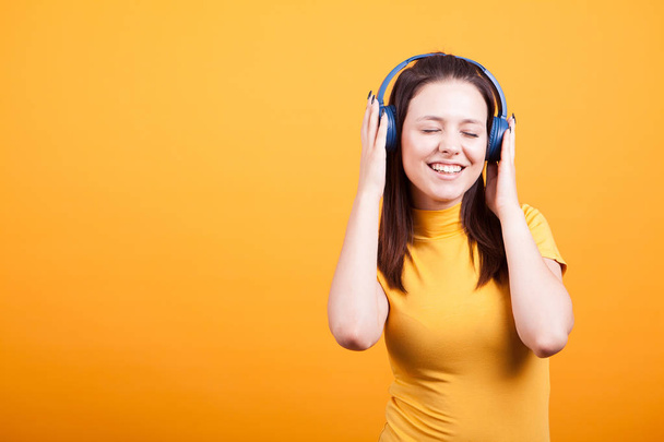 Милая молодая женщина слушает музыку в студии
 - Фото, изображение