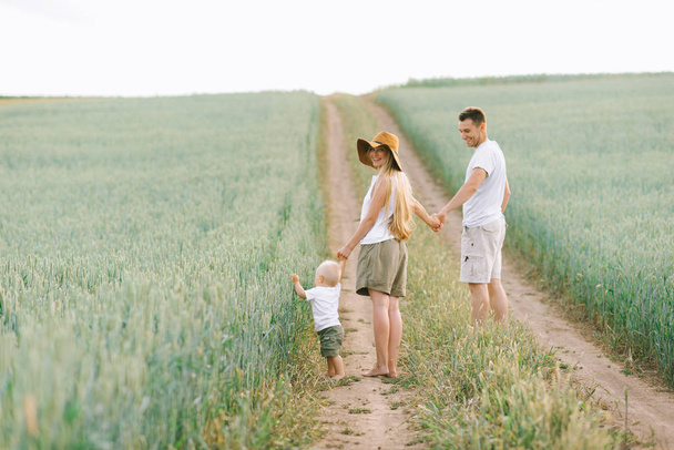 young happy family have a fun with their little baby in the field - 写真・画像