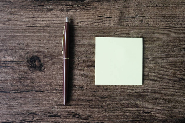 Pohled shora obrázek prázdný lístek s poznámkou papíru a pera na dřevěný stůl - Fotografie, Obrázek