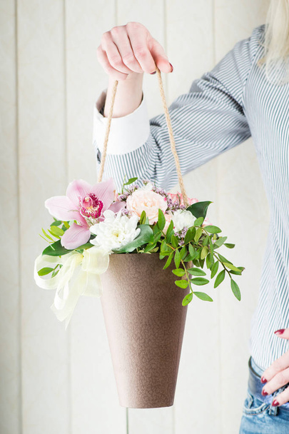 Flower arrangement in a box-cone with fresh flowers in female ha - Foto, imagen
