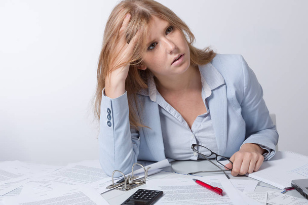 Young business woman over strained at desk full of paper work - Photo, Image