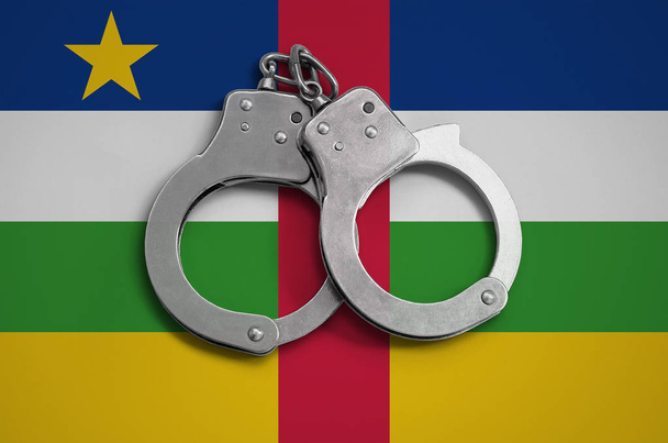 Centraal-Afrikaanse Republiek vlag en politie handboeien. Het concept van de naleving van de wet in het land en de bescherming tegen misdaad. - Foto, afbeelding