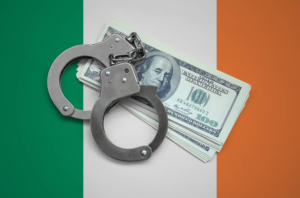 Írország lobogója bilincs és egy köteg-ból dollárok. Pénznem a korrupció az országban. Pénzügyi bűncselekmények. - Fotó, kép