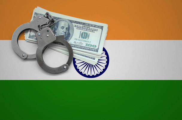 India flag  with handcuffs and a bundle of dollars. The concept of breaking the law and thieves crimes. - Photo, Image