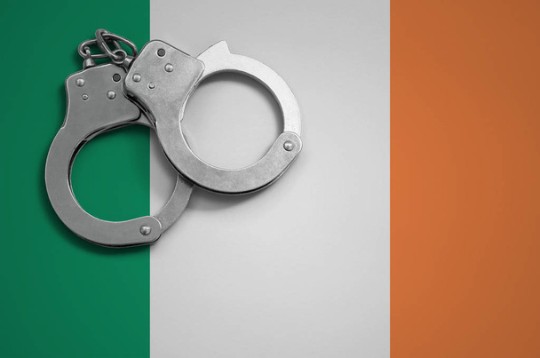 Írország lobogója és a rendőrség megbilincselve. A koncepció a bűnözés és a bűncselekmények az országban. - Fotó, kép