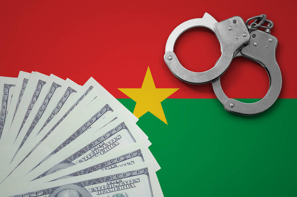 Burkina Faso zászló bilincs és egy köteg-ból dollárok. Banki műveletek bennünk valuta illegális fogalma. - Fotó, kép