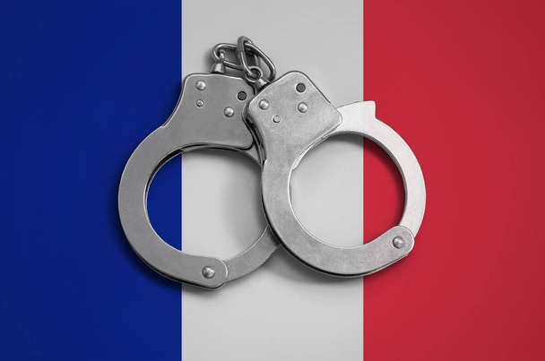 Γαλλία σημαία και αστυνομία χειροπέδες. Η έννοια της τήρησης του δικαίου της χώρας και την προστασία από το έγκλημα. - Φωτογραφία, εικόνα