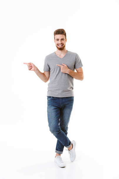 Image of handsome excited happy young man standing isolated over white wall background pointing. - Φωτογραφία, εικόνα