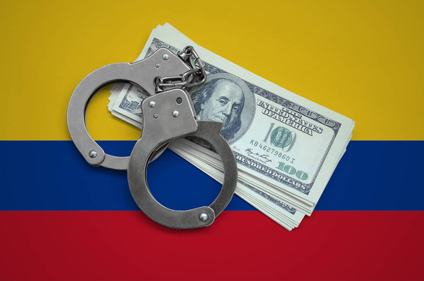 Colombia flag  with handcuffs and a bundle of dollars. Currency corruption in the country. Financial crimes. - Photo, Image