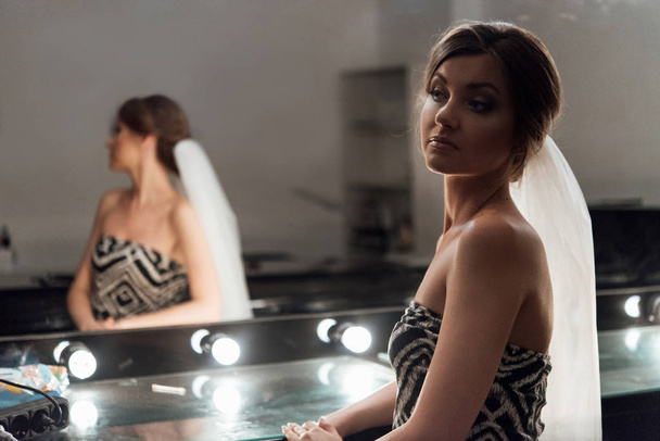 stylish gorgeous bride getting makeup in the luxury beauty saloon with big mirrors and light - Photo, image