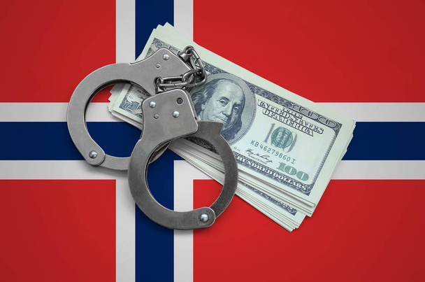 Noorwegen vlag met handboeien en een bundel die van dollars. De corruptie van de valuta in het land. Financiële misdrijven. - Foto, afbeelding