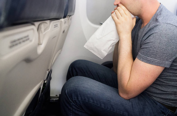 Enfermedad del aire. El hombre se siente muy mal en el avión
. - Foto, imagen