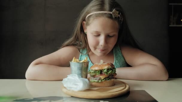 kövér lány mohón eszik egy hamburgert, koncepció, az egészséges táplálkozás - Felvétel, videó