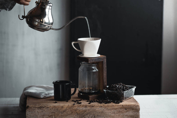 Goteo de café, Mano sosteniendo una tetera Goteo de café en la habitación
 - Foto, imagen
