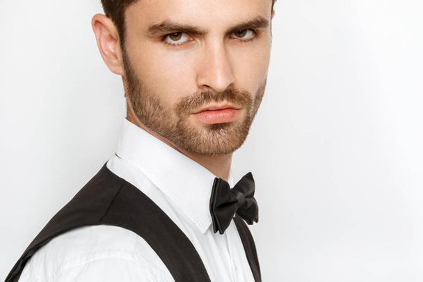 Strong commercial male model face in tuxedo on white background in studio isolaed - Foto, Imagen