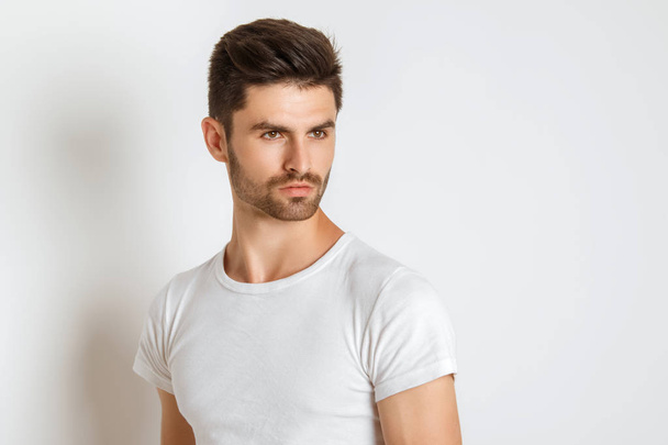 Strong face male model in casual style in white t sirt and jeans on white background in studio isolated - Fotografie, Obrázek