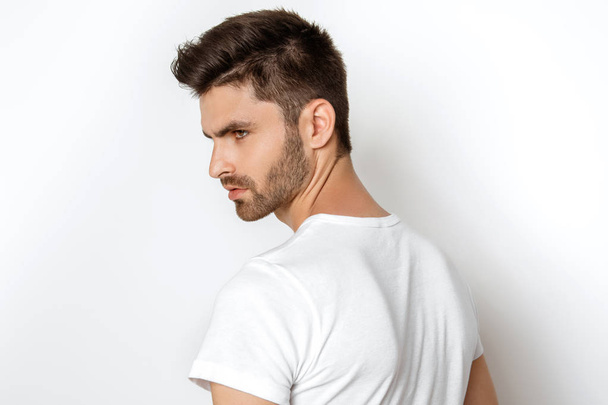 Strong face male model in casual style in white t sirt and jeans on white background in studio isolated - Foto, imagen