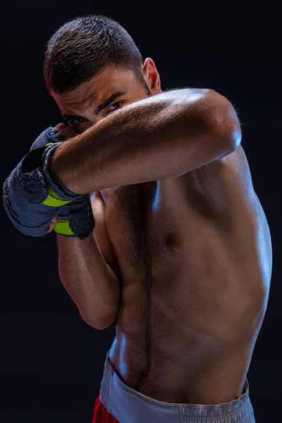 Bloqueo de brazo doble. Entrenador de boxeo mostrando técnicas defensivas. Lucha contra el deporte, club de lucha
. - Foto, Imagen
