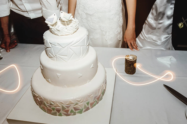 Elegante lindo bolo de casamento branco incomum com conceito de geometria e pássaros. Único doce delicioso
 - Foto, Imagem