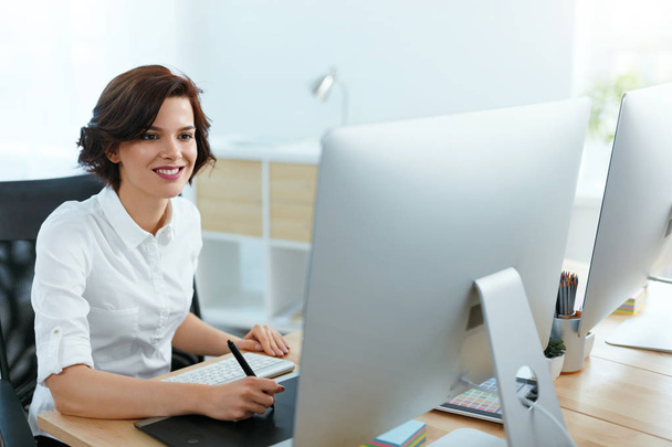 Женщина, работающая над проектом на компьютере в офисе. Женщина-дизайнер работает над планшетом цифрового рисунка. Высокое разрешение
 - Фото, изображение
