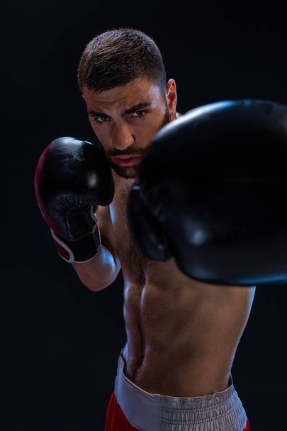 Sert erkek boksör boks duruş siyah arka plan karşı poz portresi. - Fotoğraf, Görsel