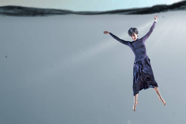 Woman dancer in clear blue water - Фото, зображення