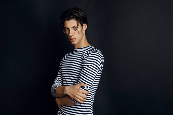 Sexy male model in sailors black and white shirt on black background - Zdjęcie, obraz