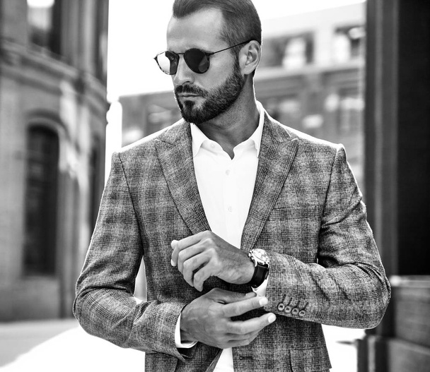 Portrait of sexy handsome fashion businessman model dressed in elegant checkered suit posing on street background. Metrosexual - Zdjęcie, obraz