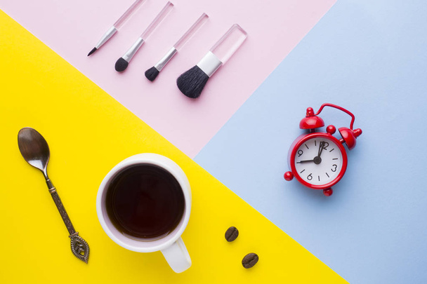 Cup of coffee, Watch the Clock and make-up brushes on colorful backgrounds. Concept business morning - Foto, Bild