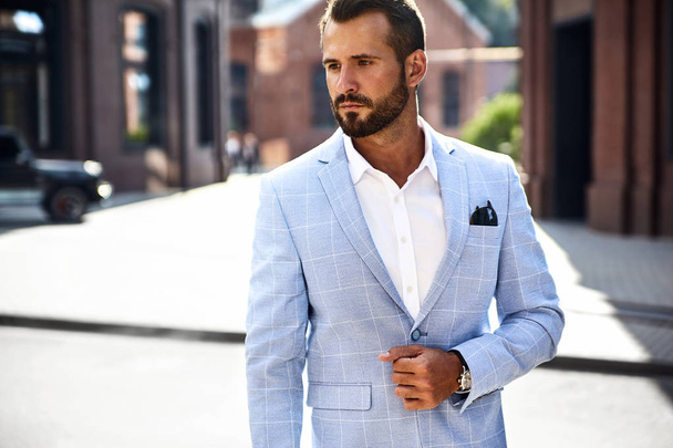 Portrait of sexy handsome fashion businessman model dressed in elegant blue suit posing on street background. Metrosexual - Φωτογραφία, εικόνα