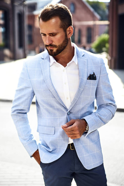 Portrait of sexy handsome fashion businessman model dressed in elegant blue suit posing on street background. Metrosexual - Foto, Imagen
