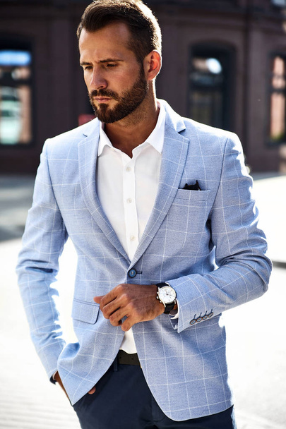Portrait of sexy handsome fashion businessman model dressed in elegant blue suit posing on street background. Metrosexual - Foto, afbeelding