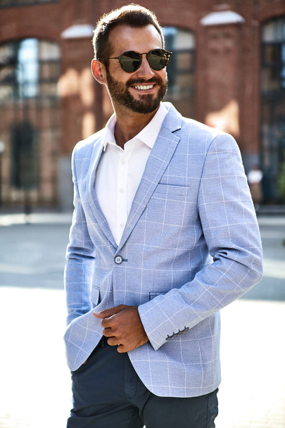 Portrait of sexy handsome fashion businessman model dressed in elegant blue suit posing on street background. Metrosexual - Foto, Imagem