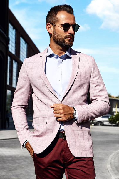 Portrait of sexy handsome fashion businessman model dressed in elegant suit posing on street background. Metrosexual - 写真・画像