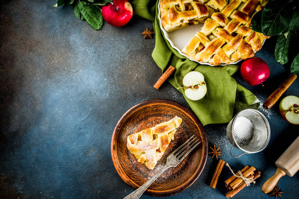 伝統的な秋のパン、自家製アップルパイとシナモン、圧延ロール、砂糖の粉、新鮮なリンゴ、スパイスと暗い青色の背景コピー スペース平面図 - 写真・画像