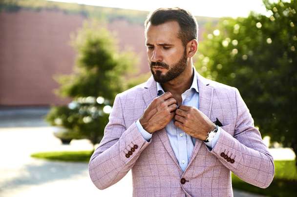 Portrait of sexy handsome fashion businessman model dressed in elegant suit posing on street background. Metrosexual - Foto, Bild