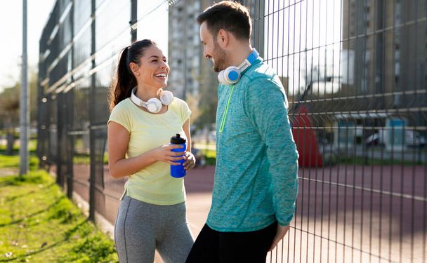 Young fitness couple running together in urban area - Photo, Image