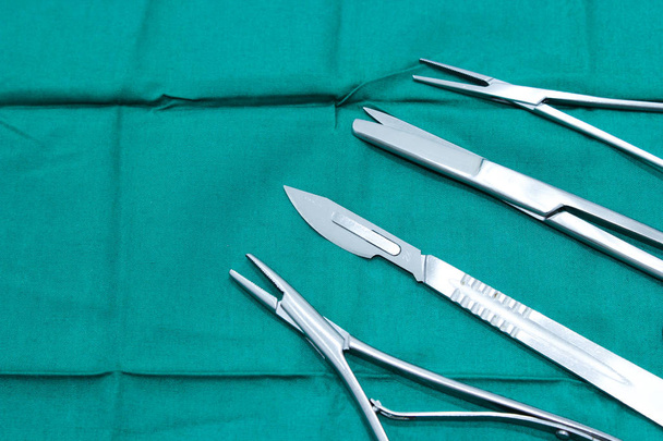 Хирургические инструменты на медицинской зеленой ткани
 - Фото, изображение