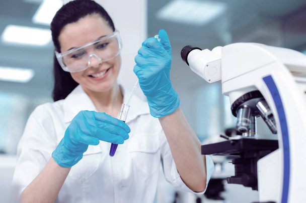 Joyful positive scientist taking a test sample - Фото, изображение