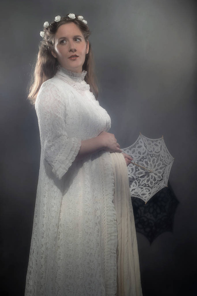 Történelmi terhes barna nő fehér ruhában gazdaság esernyő. - Fotó, kép