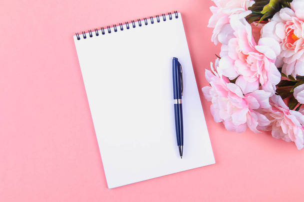 Empty notebook with blue pen on a pink pastel background. mock-up, frame, template - Фото, изображение