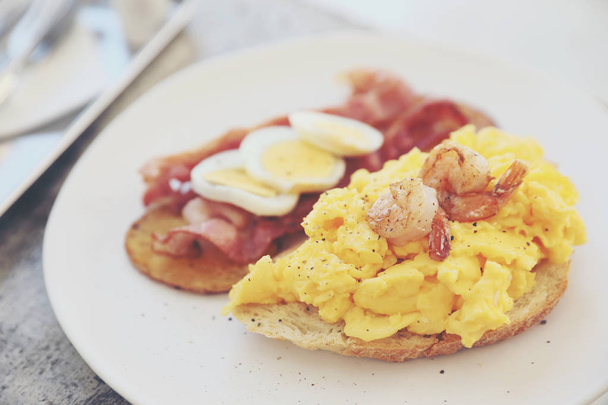 朝食のスクランブルエッグ、フライド ポテト ベーコンとエビ - 写真・画像