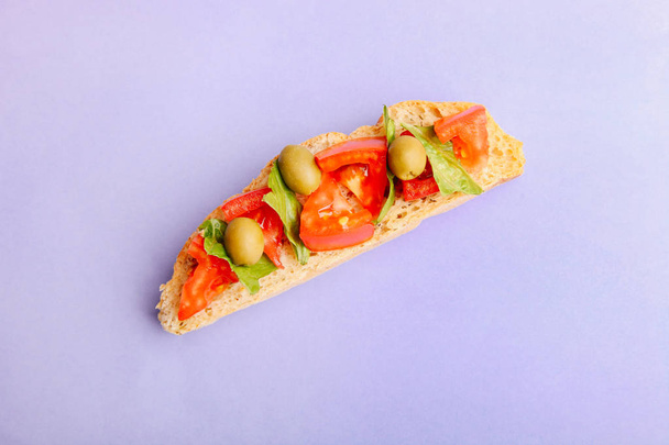 Traditional Italian bruschetta on a purple background. Top view. - Photo, Image