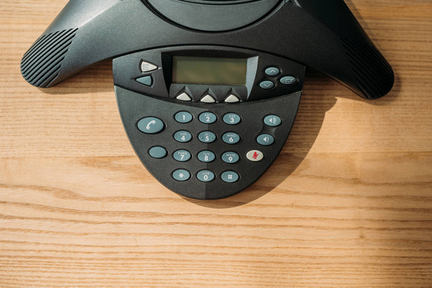 top view of speakerphone on wooden table at office - Zdjęcie, obraz