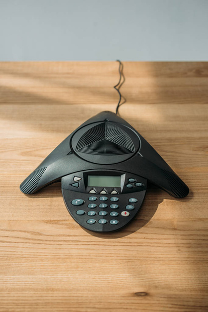 high angle view of speakerphone on wooden table at office - Foto, Imagem