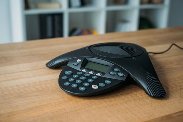 téléphone de conférence sur table en bois au bureau avec des étagères floues sur fond
 - Photo, image