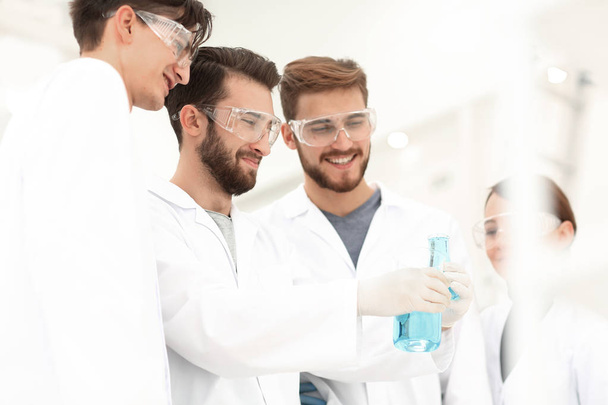 group of scientists working with chemicals - Foto, Bild