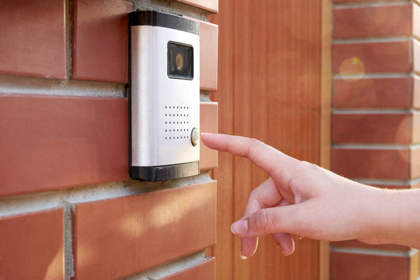 The female hand presses a button doorbell with camera and intercom - Photo, Image
