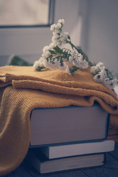 Details of still life in the home interior. Sweater, cup, wool, cozy, book, candle. Moody. Cosy autumn winter concept. Copy space - Photo, Image